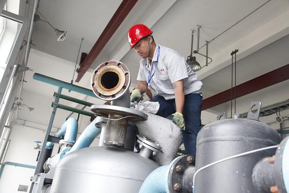 公用车间苏昭仪在给过滤器装填活性炭